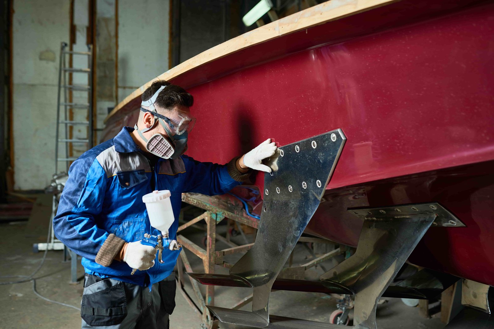 a man in uniform painting a boat