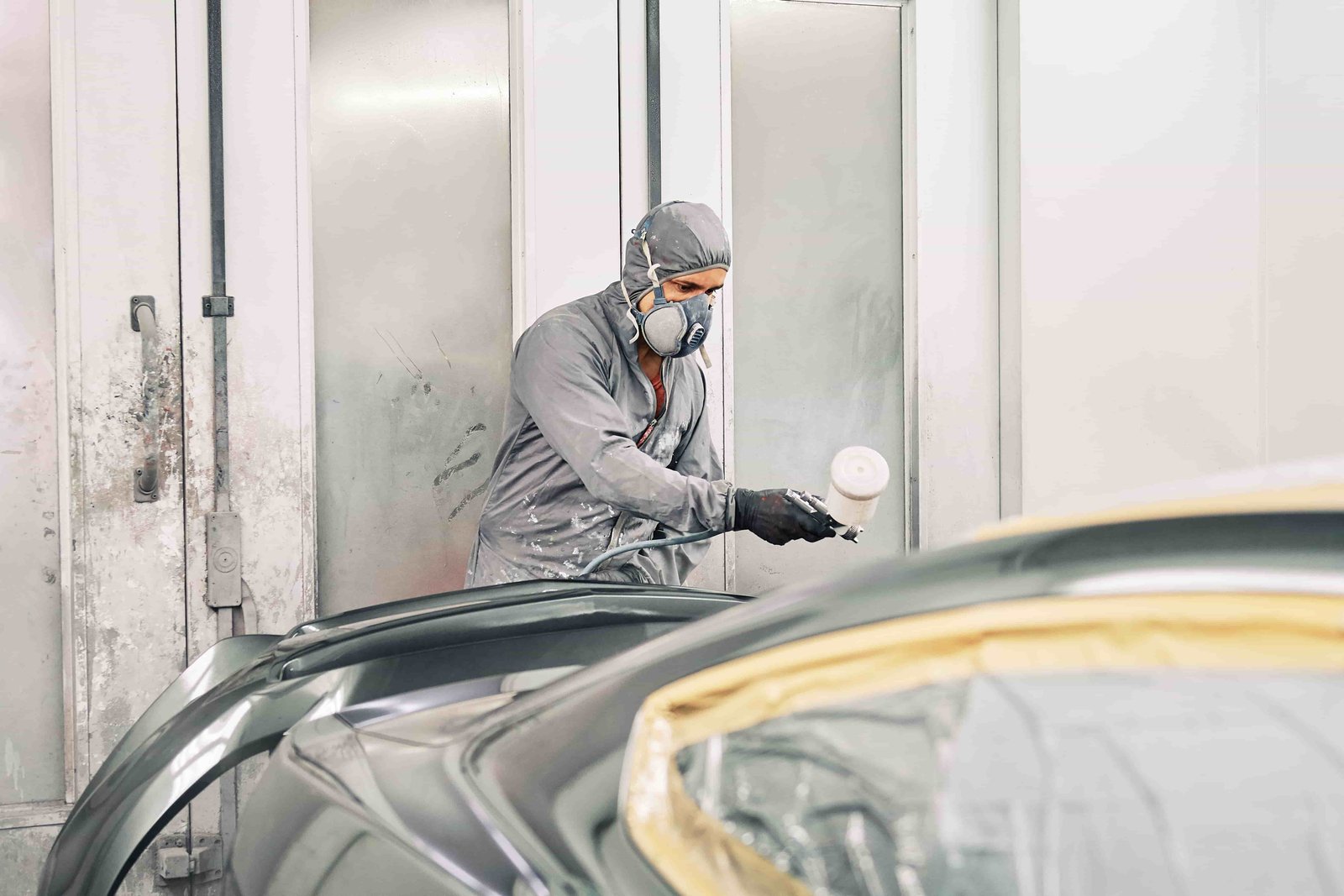 a man painitng a car in a workshop